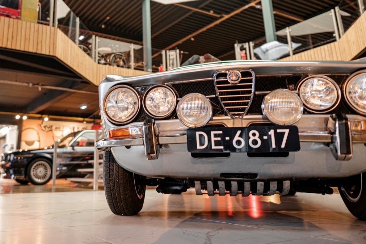 Vooraanzicht van een klassieke Alfa Romeo met extra verstralers in onze hal, waar u uw Alfa Romeo Giulia kunt verkopen
